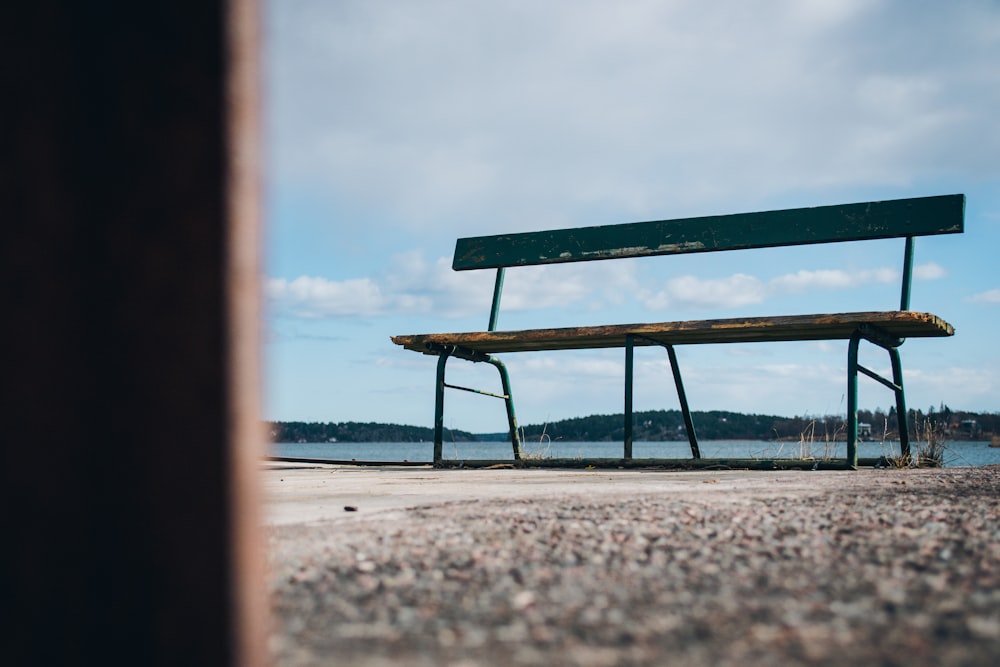 a bench sitting on top of a sandy beach