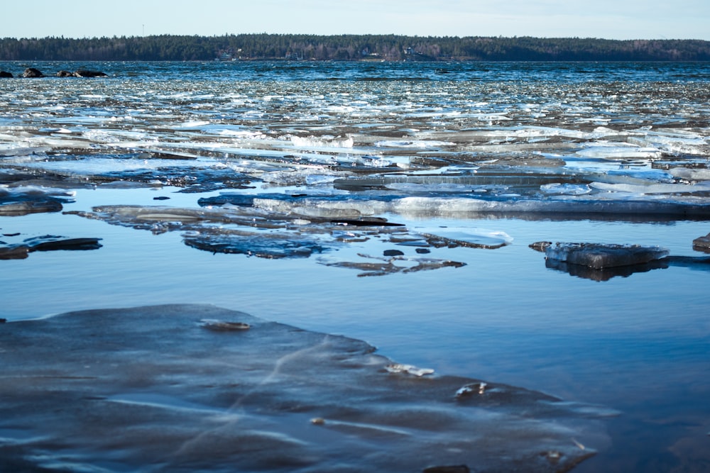 a body of water surrounded by ice covered rocks