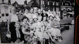 A vintage-style photograph of a group of mothers enjoying a picnic in a lush green park.