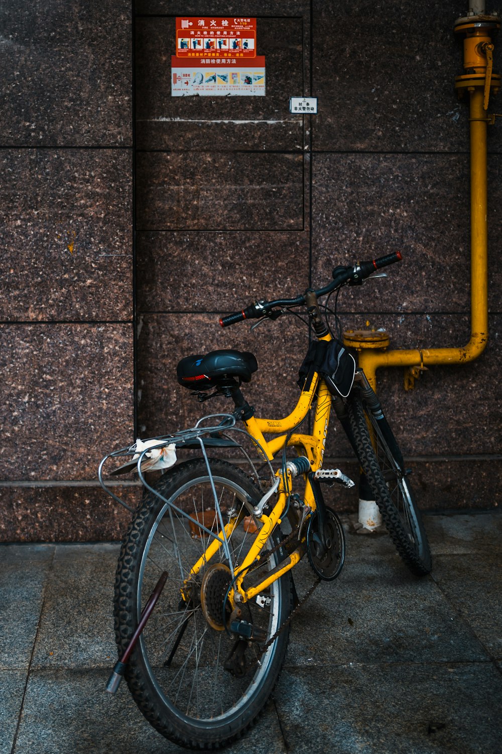 a yellow bicycle parked next to a building