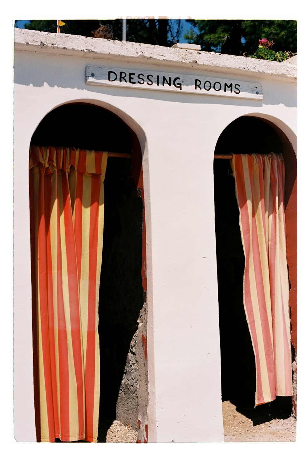 a white building with red and yellow striped curtains