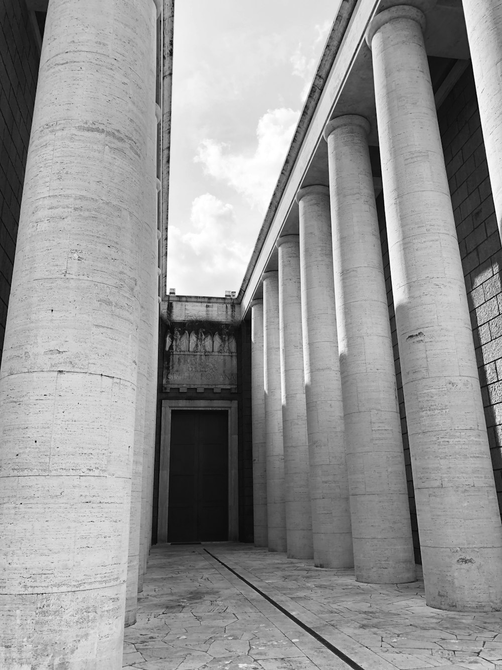 a black and white photo of columns and a building