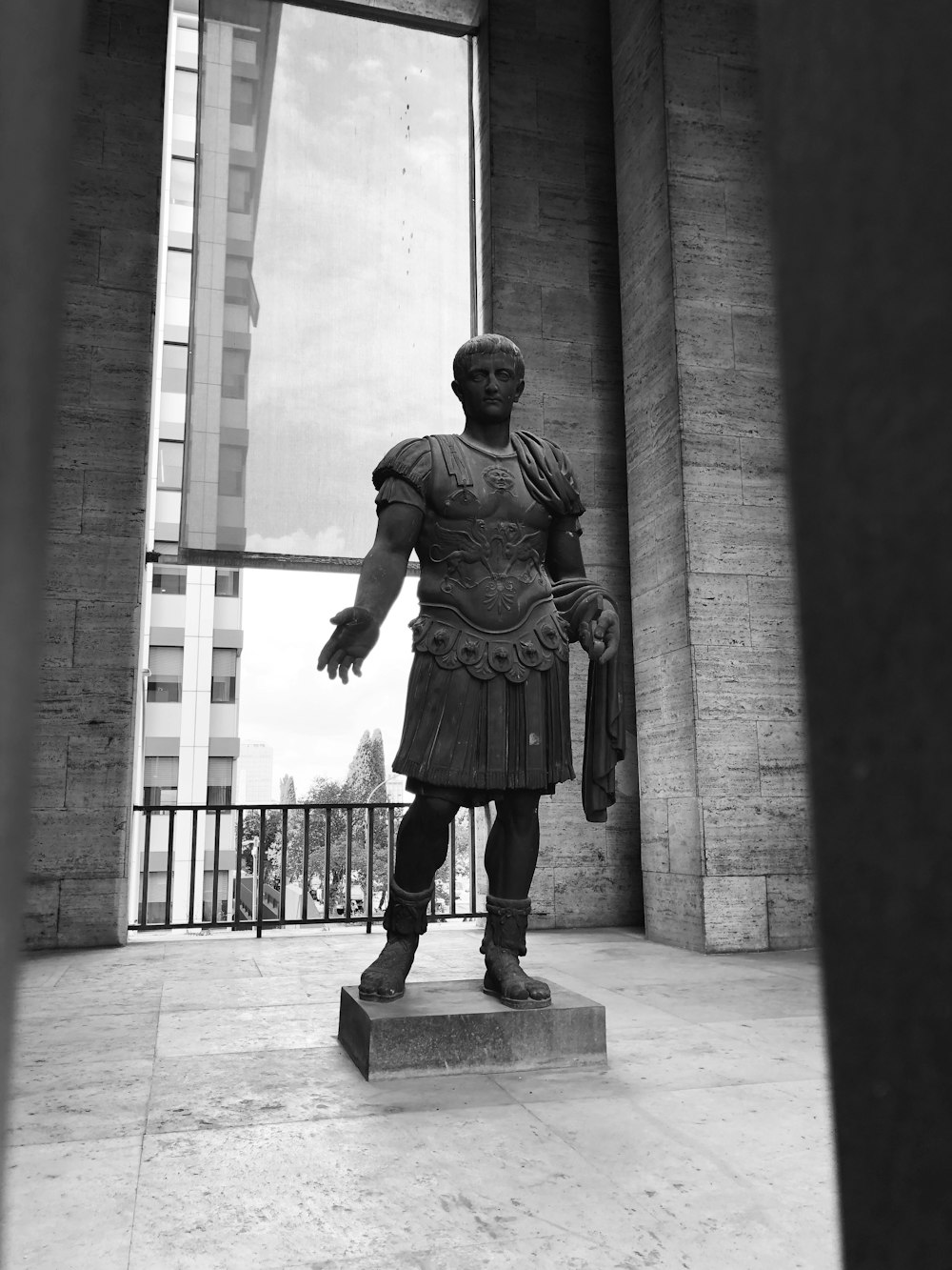 a black and white photo of a statue of a roman soldier