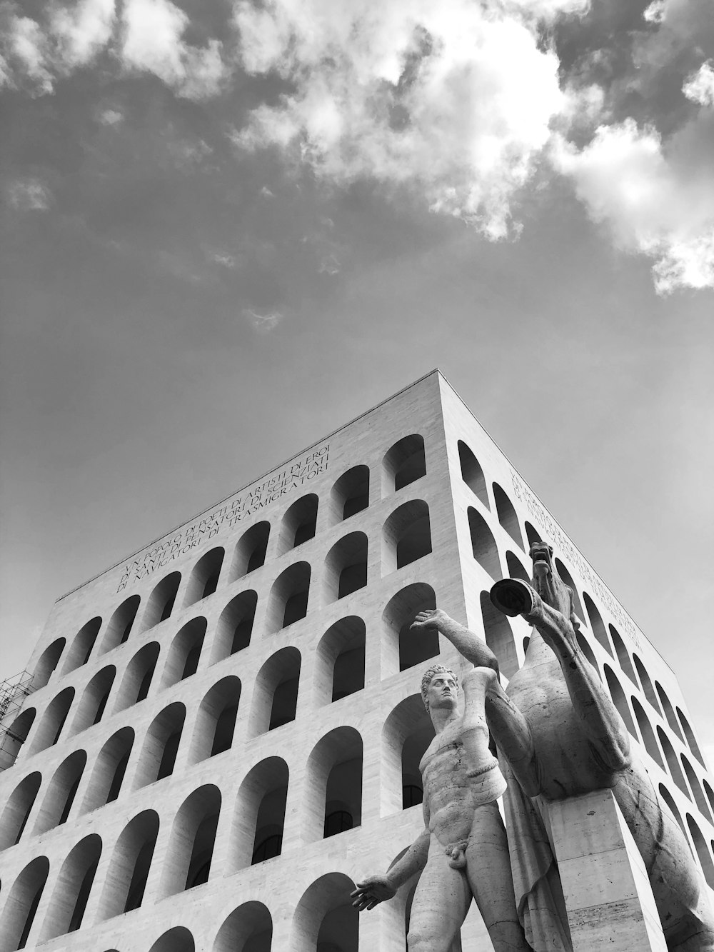 a black and white photo of a statue in front of a building