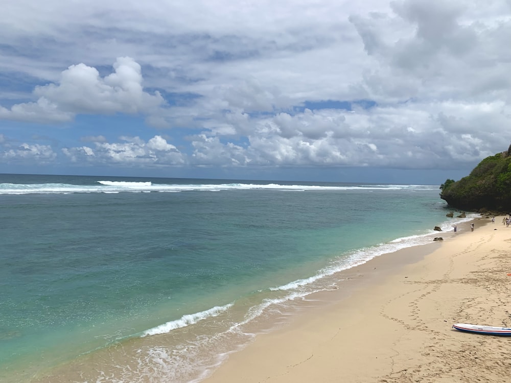 a view of a beach with a surfboard in the foreground