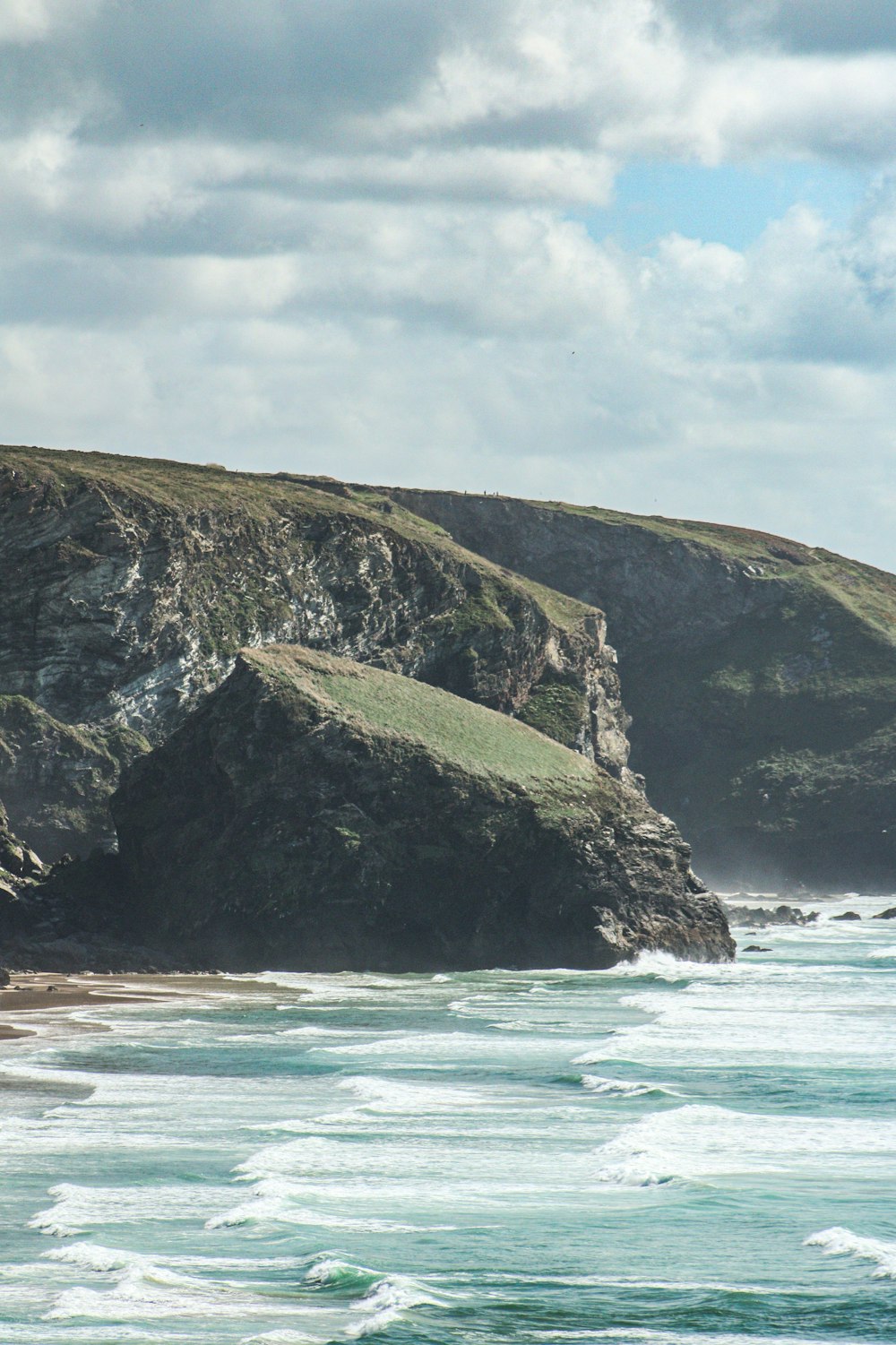 a couple of sheep standing on top of a lush green hillside