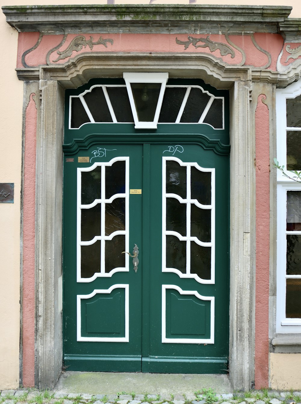 a green door with two windows in front of a building