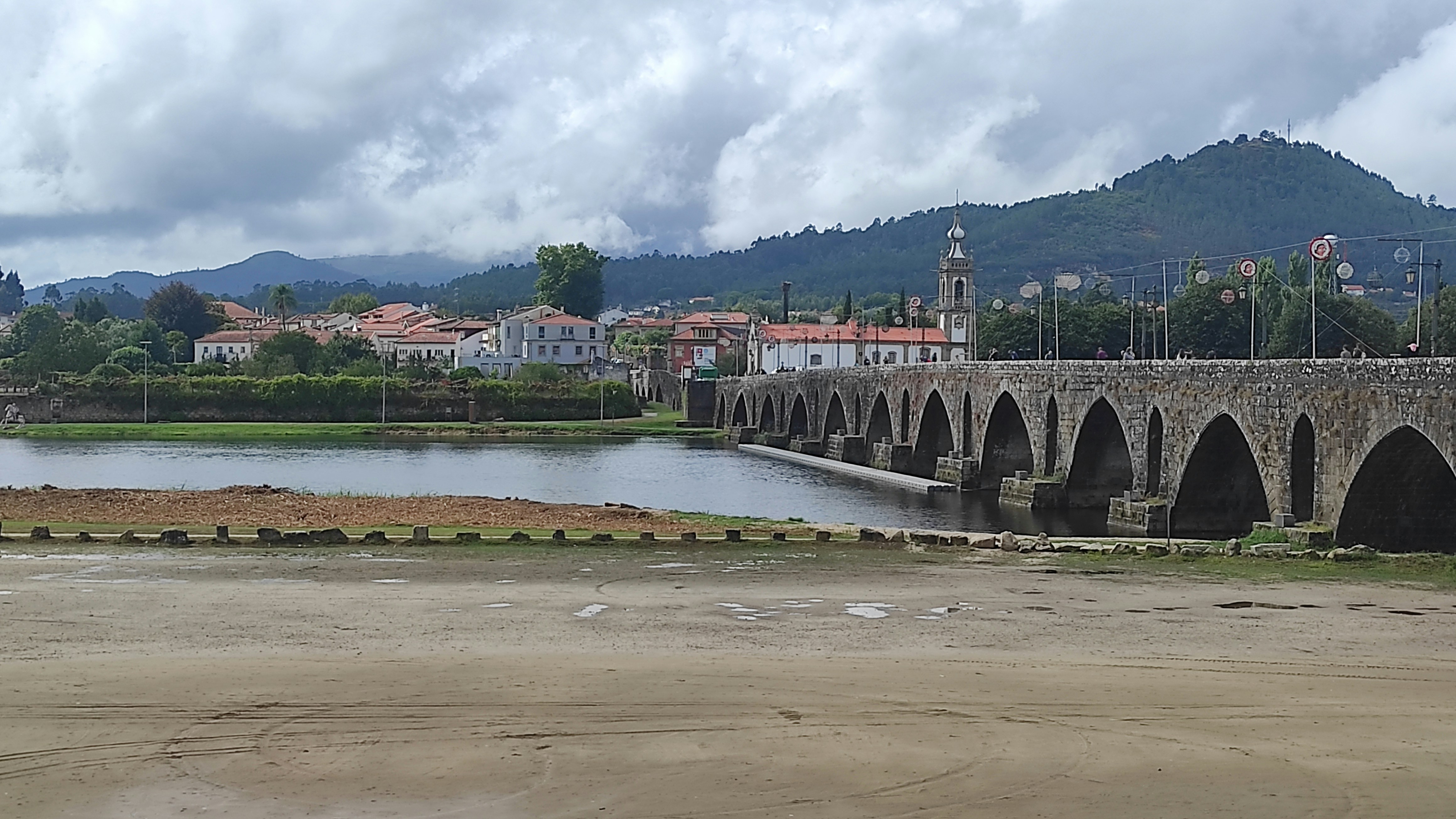 a bridge over a river with a town in the background