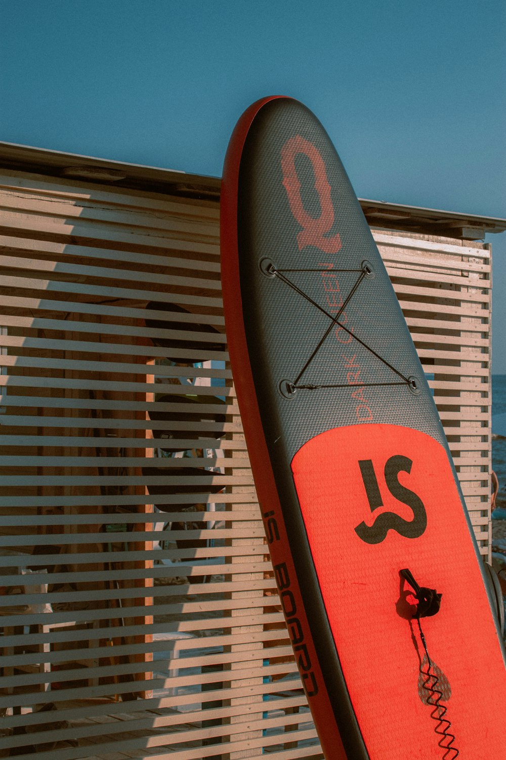 a surfboard leaning up against a window with blinds
