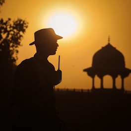 a silhouette of a man holding a stick in front of a sunset