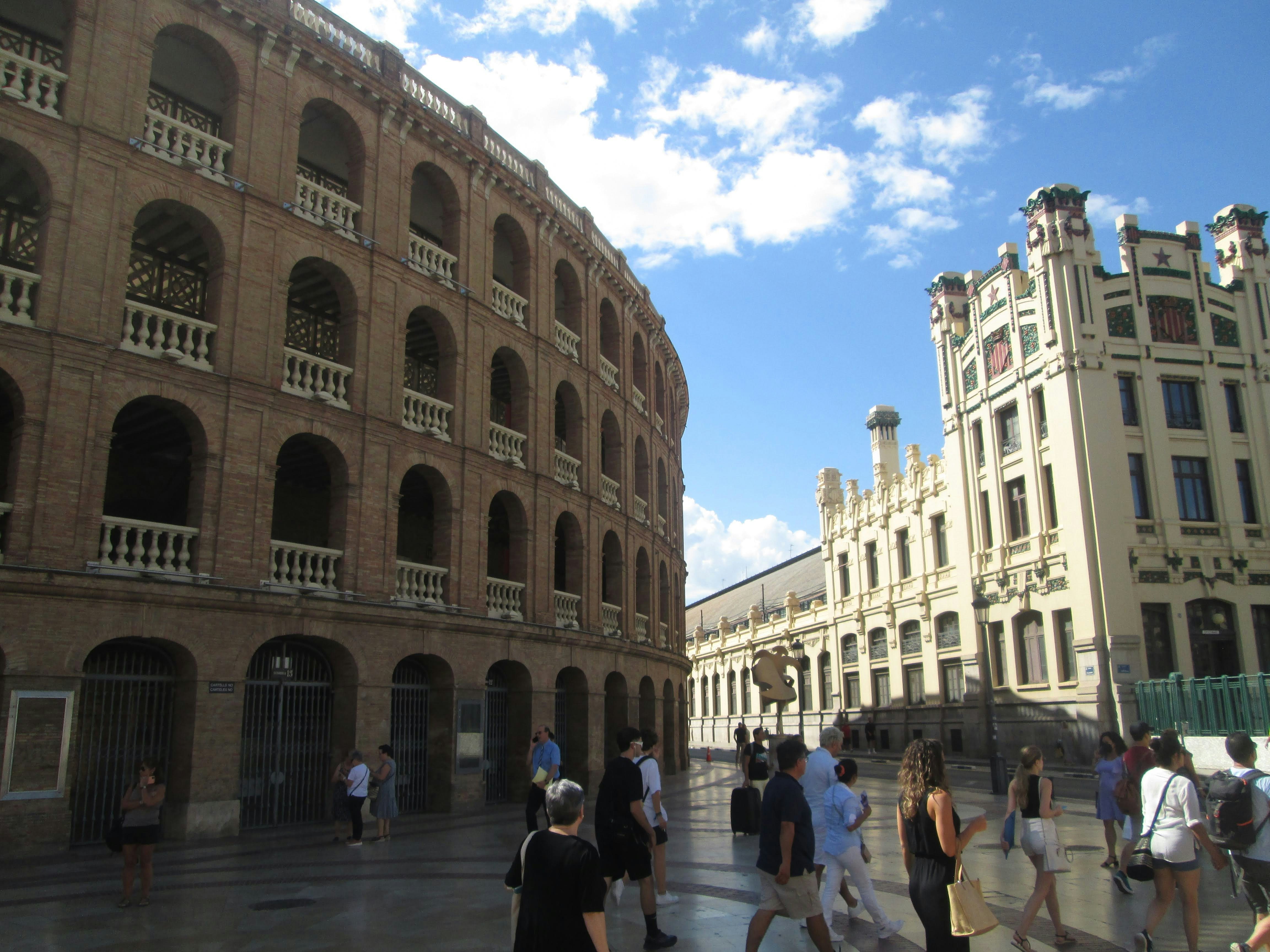 a group of people walking down a street next to tall buildings