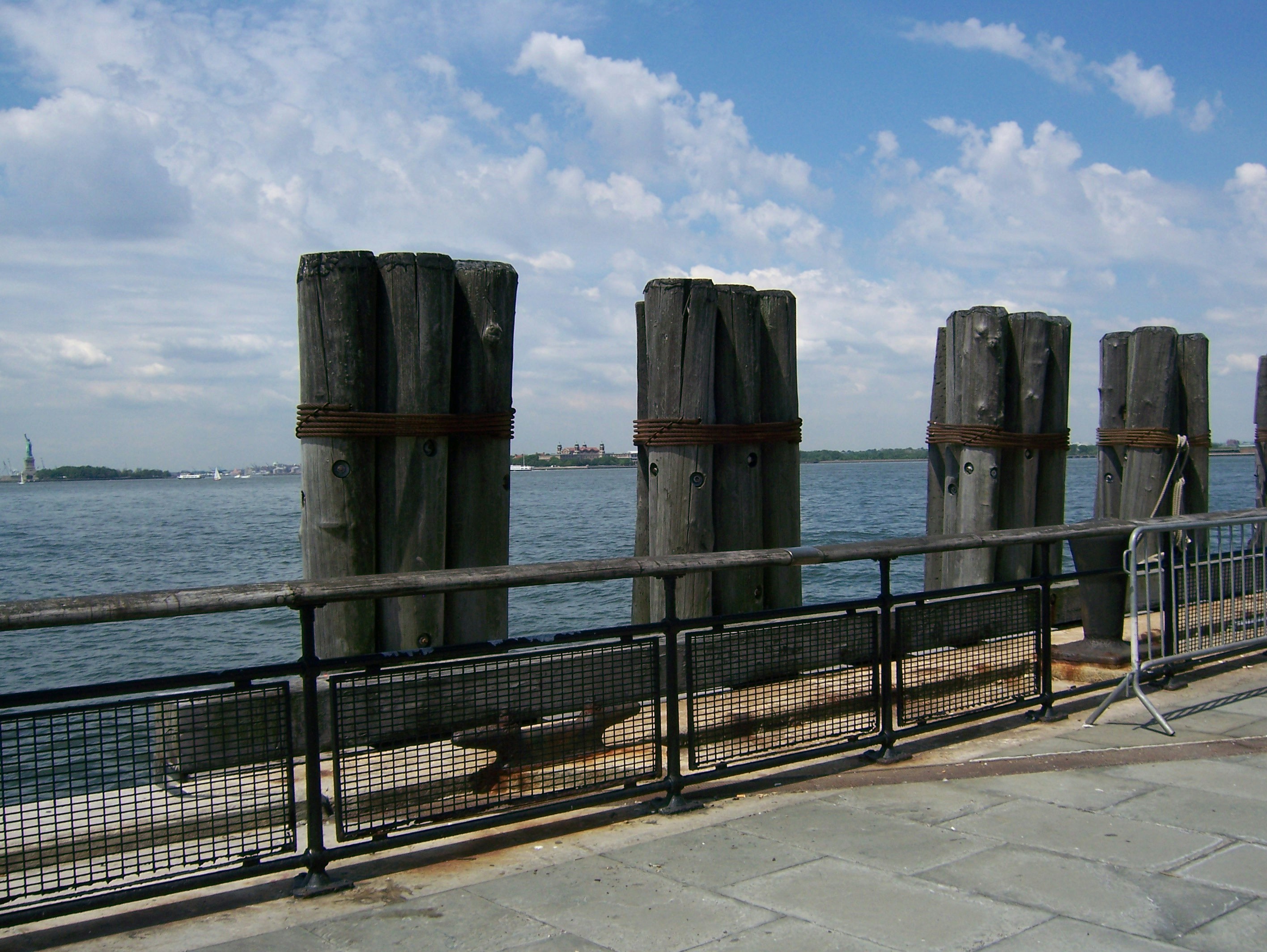 a metal fence next to a body of water