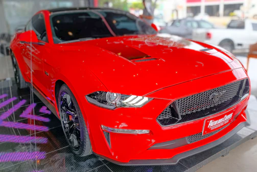 A vibrant red sports car after a full exterior and interior detail.