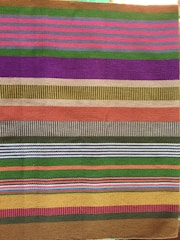 Brightly colored striped hair bow handmade with textured fabric.