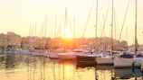 Sailboats gently rocking in the harbor under a golden sunset.