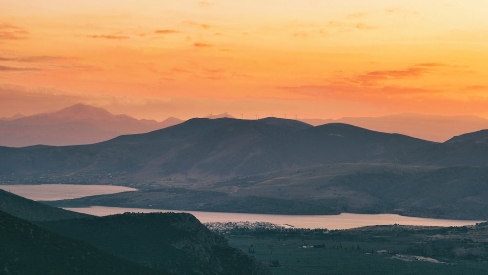 a view of a mountain range with a lake in the foreground