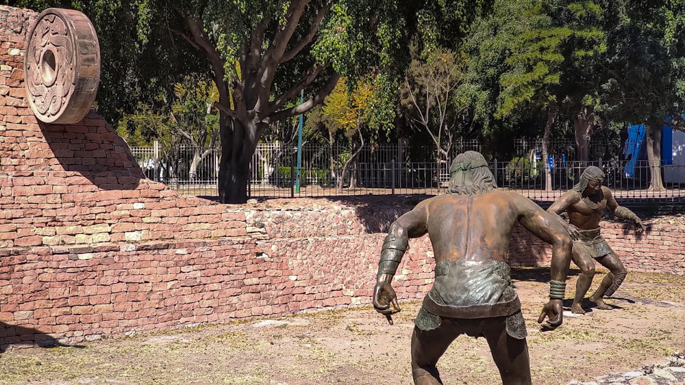 a statue of a man standing next to a brick wall