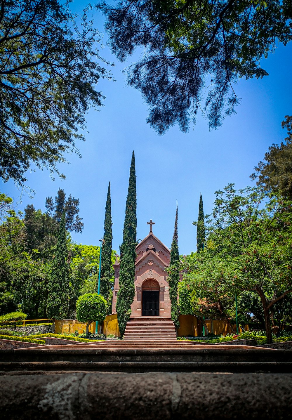 a church with a steeple surrounded by trees