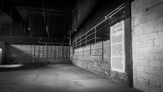 Wide shot of a minimalist cyber-style warehouse interior illuminated by glowing blue LED pathways and subtle ambient lighting.