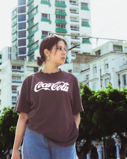 A model wearing the Lithuania Tee shirt paired with casual jeans, standing in a city park.