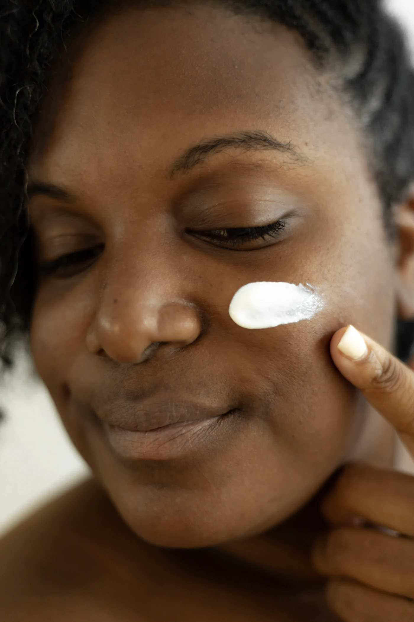 A woman smoothing lotion onto her skin