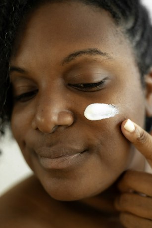 Woman applying skincare lotion to her face