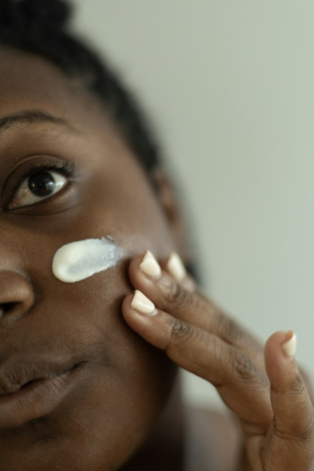 Una donna che mette la crema sul suo viso