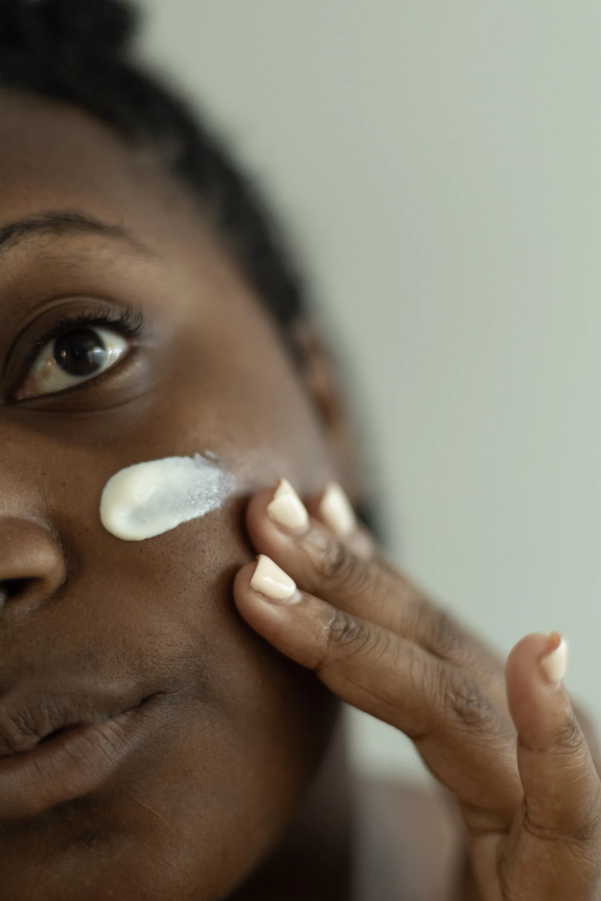 Woman layering cream onto her face