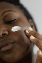 a woman is putting a lotion on her face