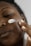 A close-up of a person applying cream to their face in a bright bathroom.