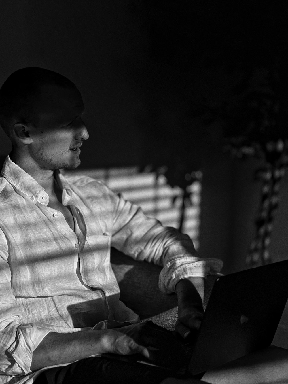 a man sitting in a chair using a laptop computer