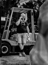 a man standing next to a forklift talking on a cell phone