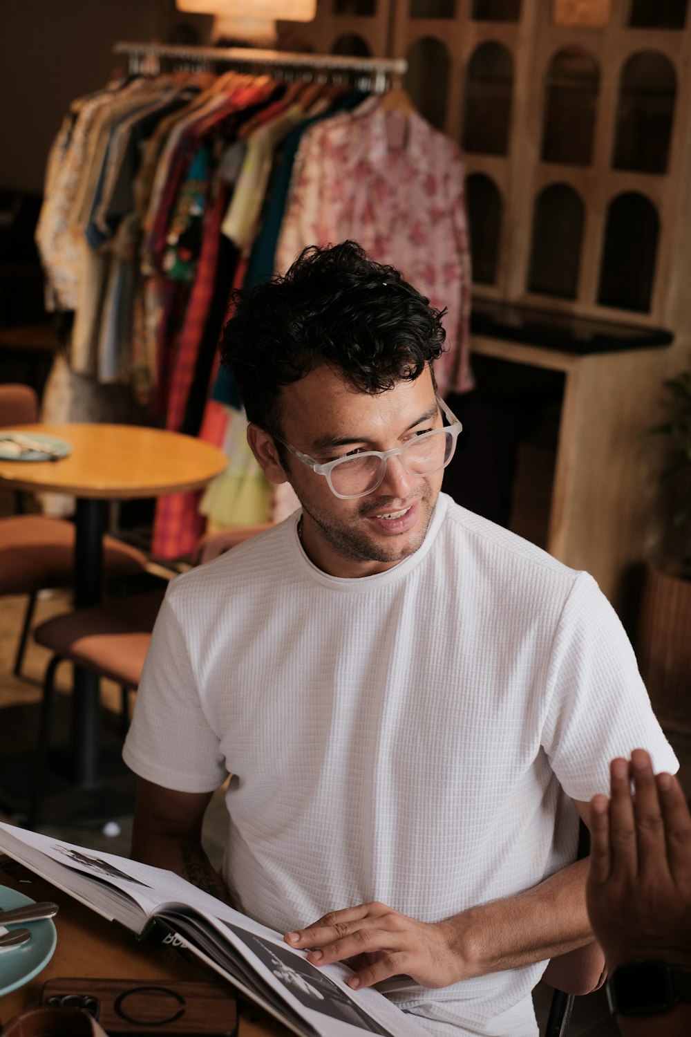 a man wearing glasses and reading a book