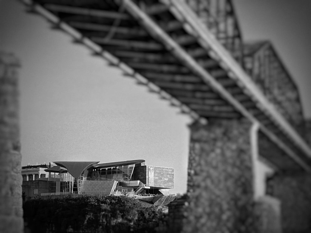 a black and white photo of a building under a bridge