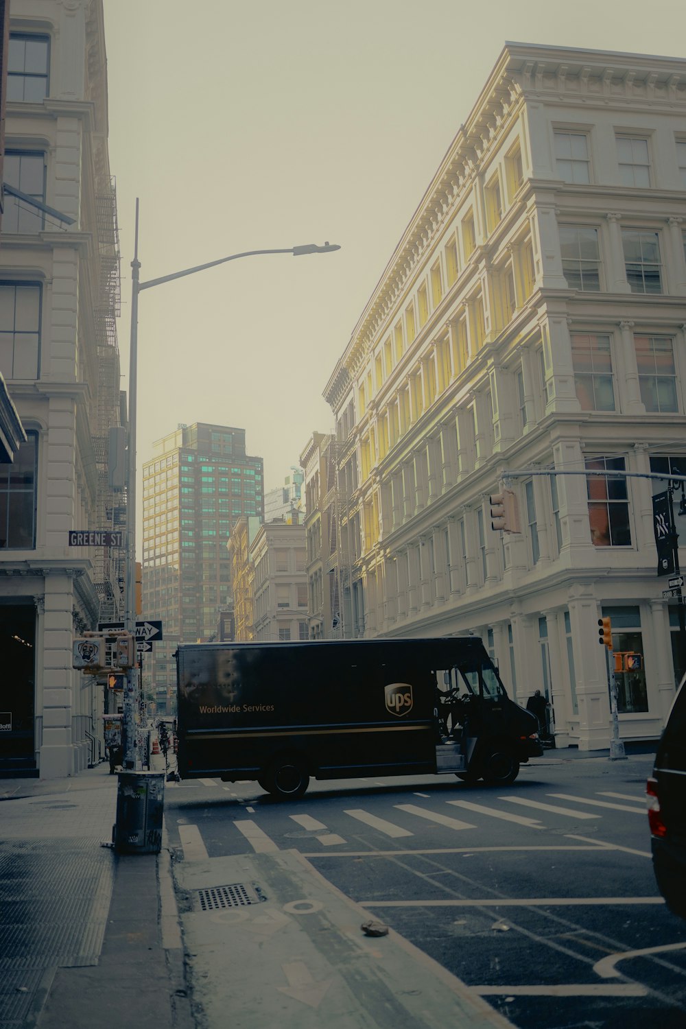 a black van driving down a street next to tall buildings