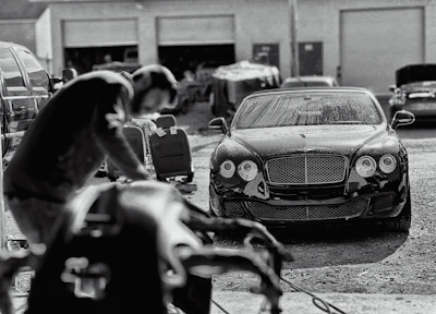 A luxury car being carefully detailed by a professional in a spotless workshop
