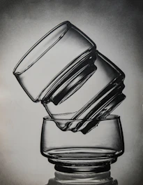Clear glass cups catching sunlight on a kitchen counter, highlighting their sleek design.