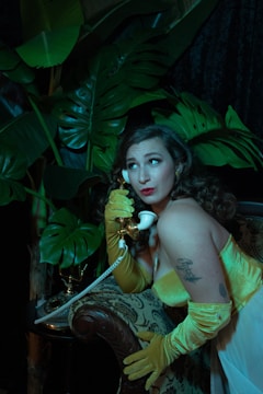 Ethyl with her 1960s flip hairstyle wearing a mustard-yellow dress.