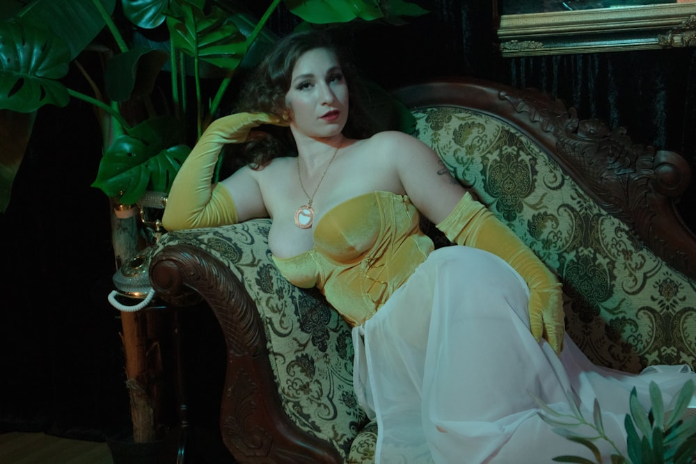 a woman in a yellow dress laying on a couch