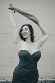 A stylish woman in an elegant dress posing confidently.