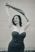 A confident woman smiling, dressed elegantly in a chic outfit.