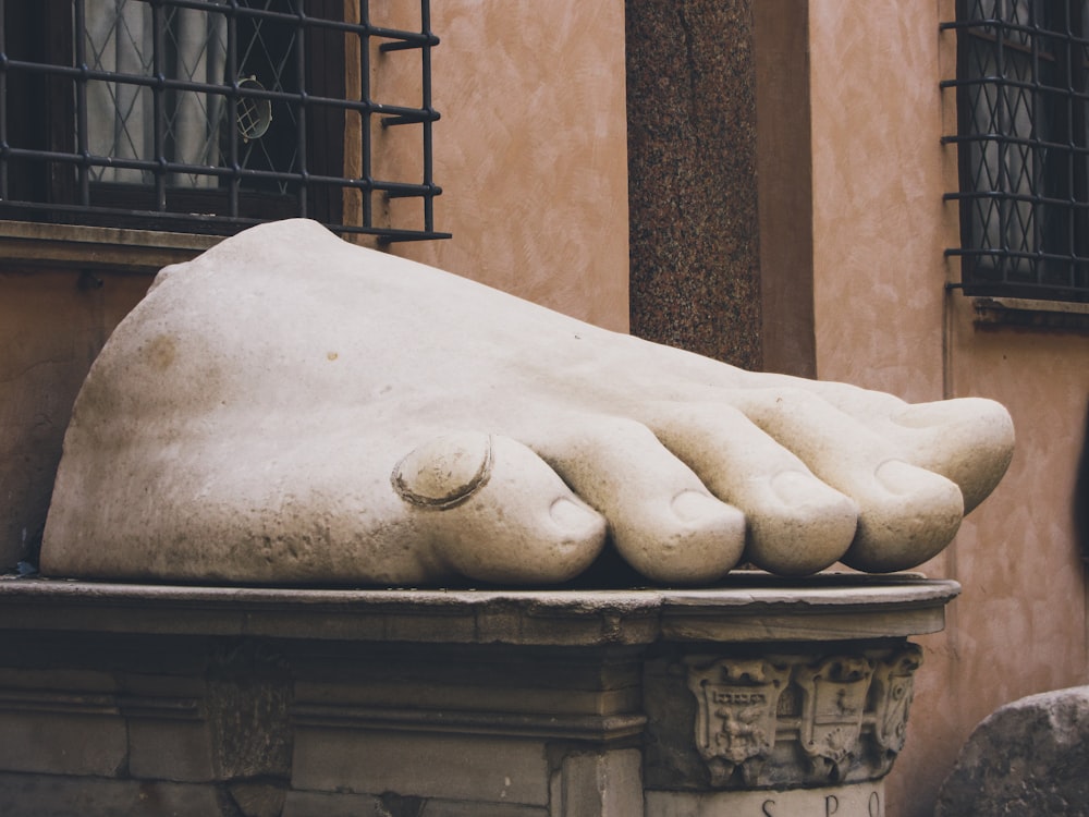 una estatua de un pie descansando sobre una repisa