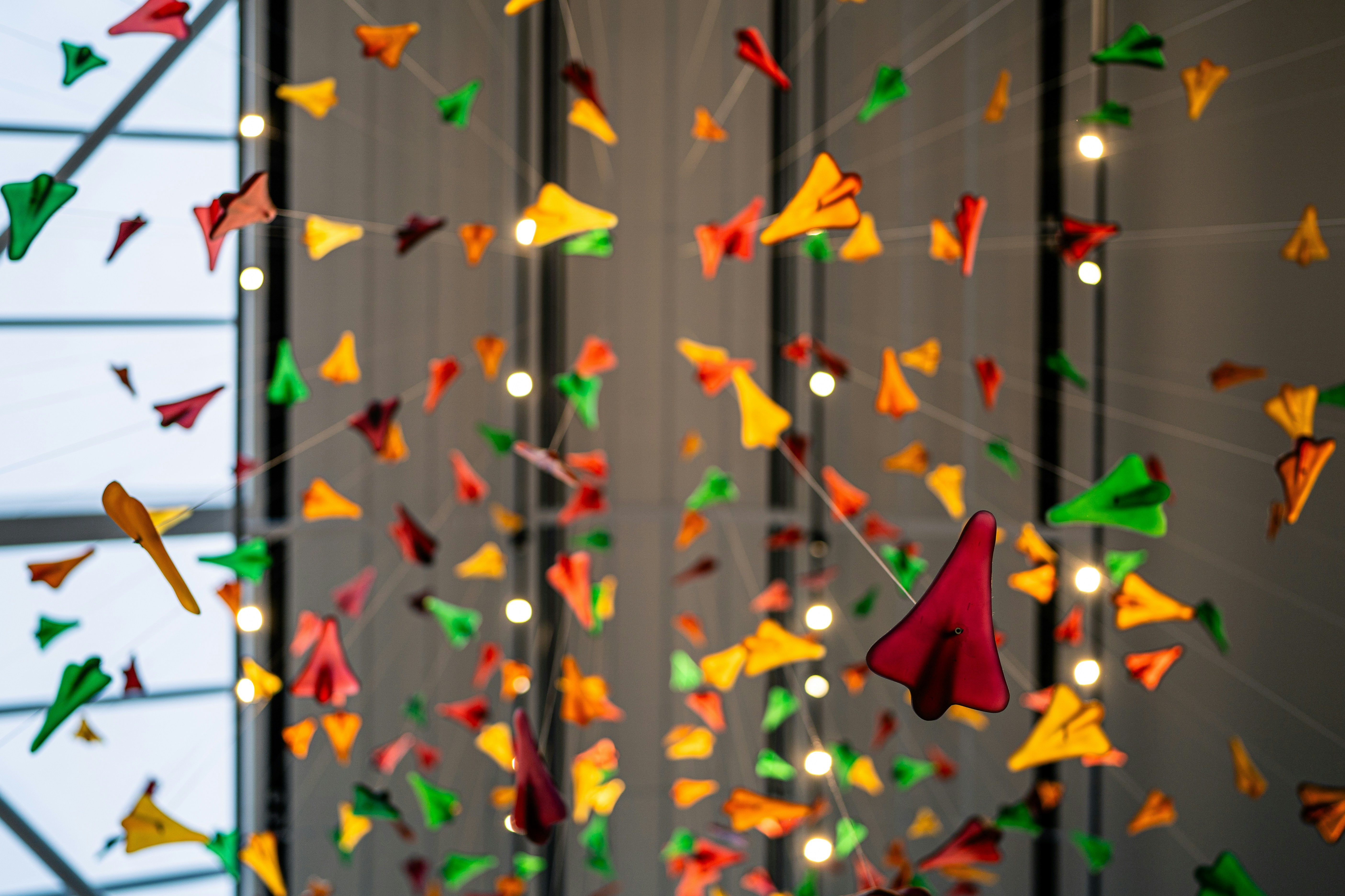 A group of colorful kites hanging from a ceiling photo Free Image on