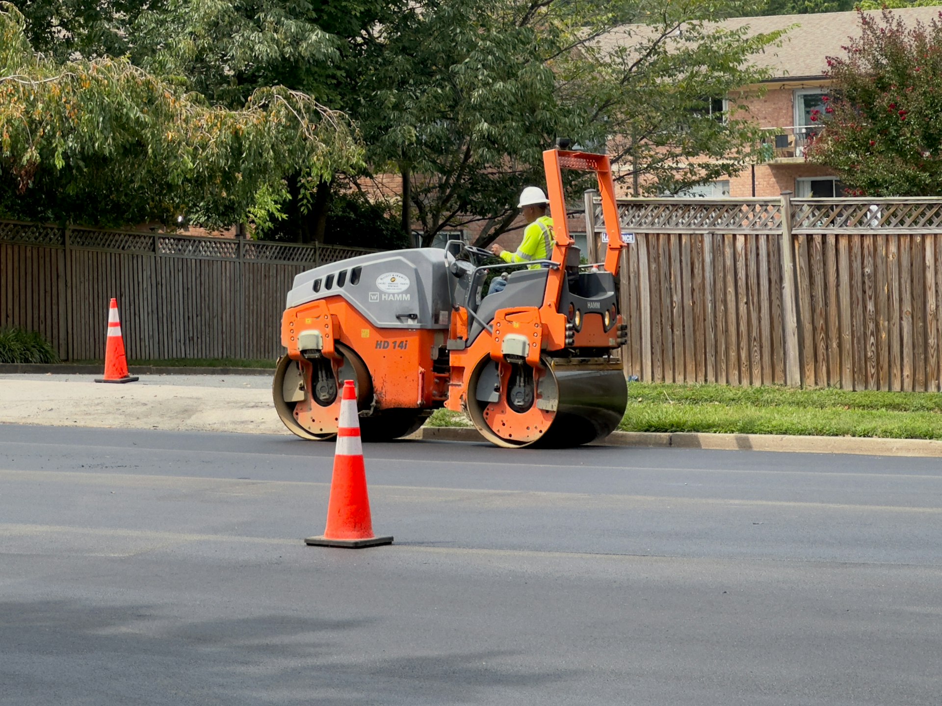 Road construction excavator paving fresh asphalt