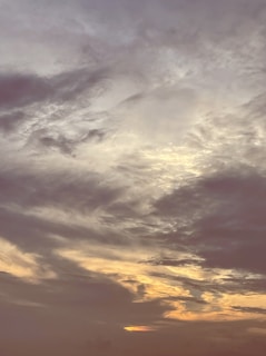 A vibrant painting of a vast sky filled with swirling clouds and soft light, capturing Gaetano Siniscalchi's signature style.