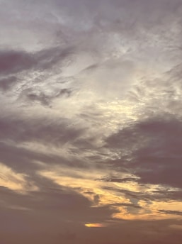 A vibrant painting of a vast sky filled with swirling clouds and soft light, capturing Gaetano Siniscalchi's signature style.