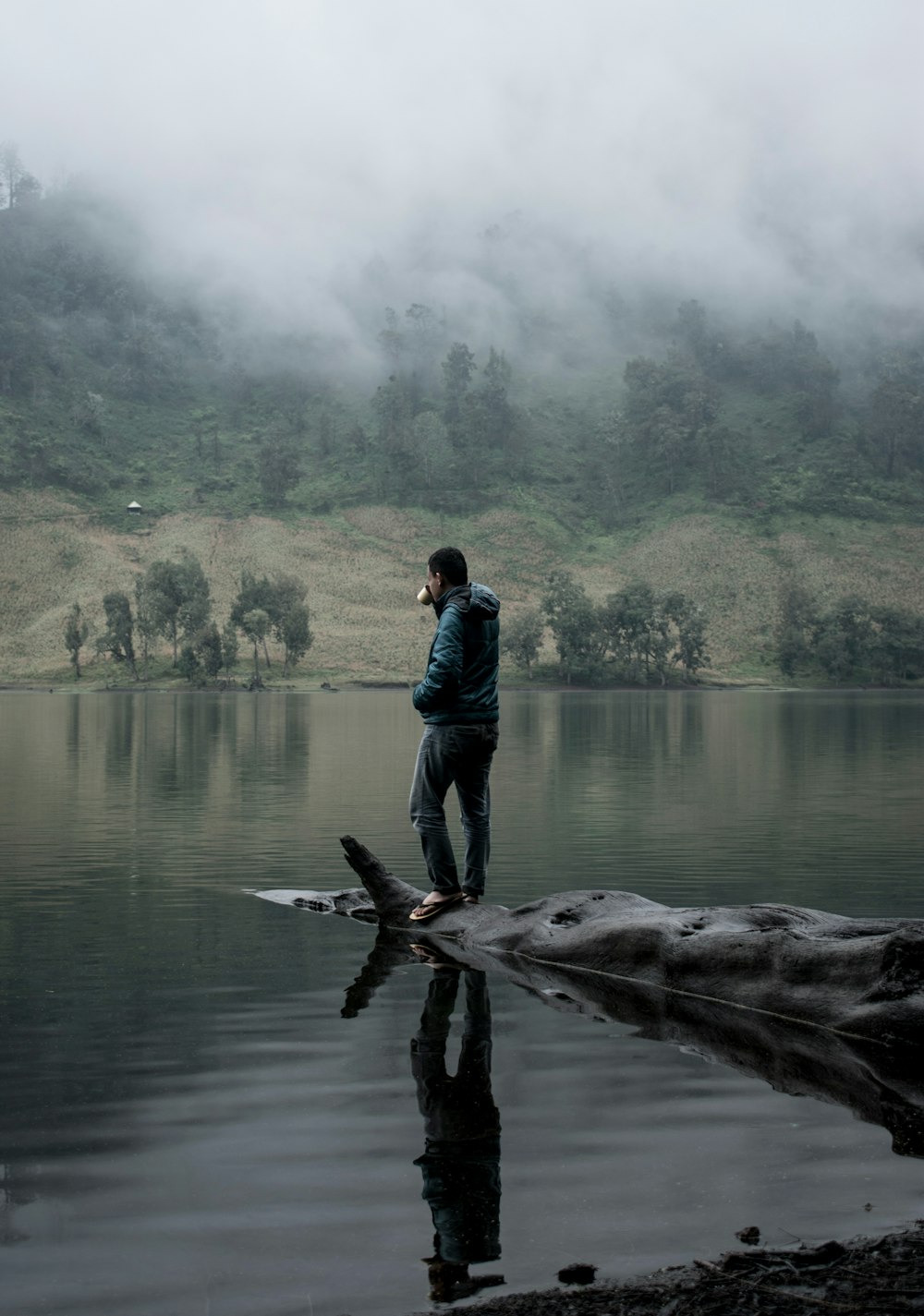 a man standing on a log in the water