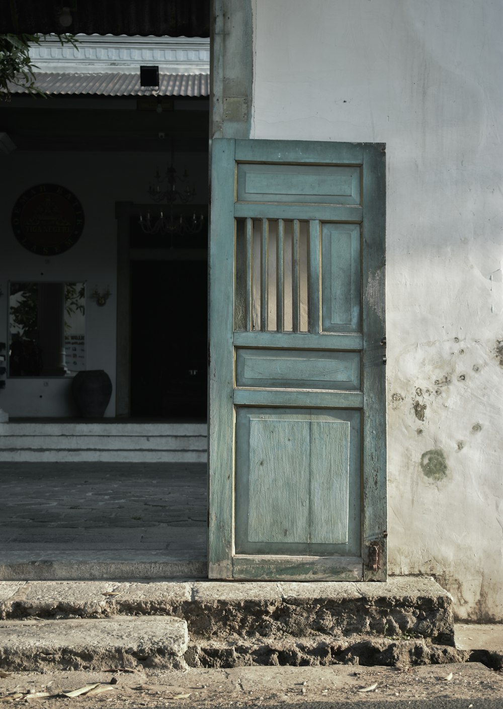 uma porta antiga está aberta na lateral de um edifício