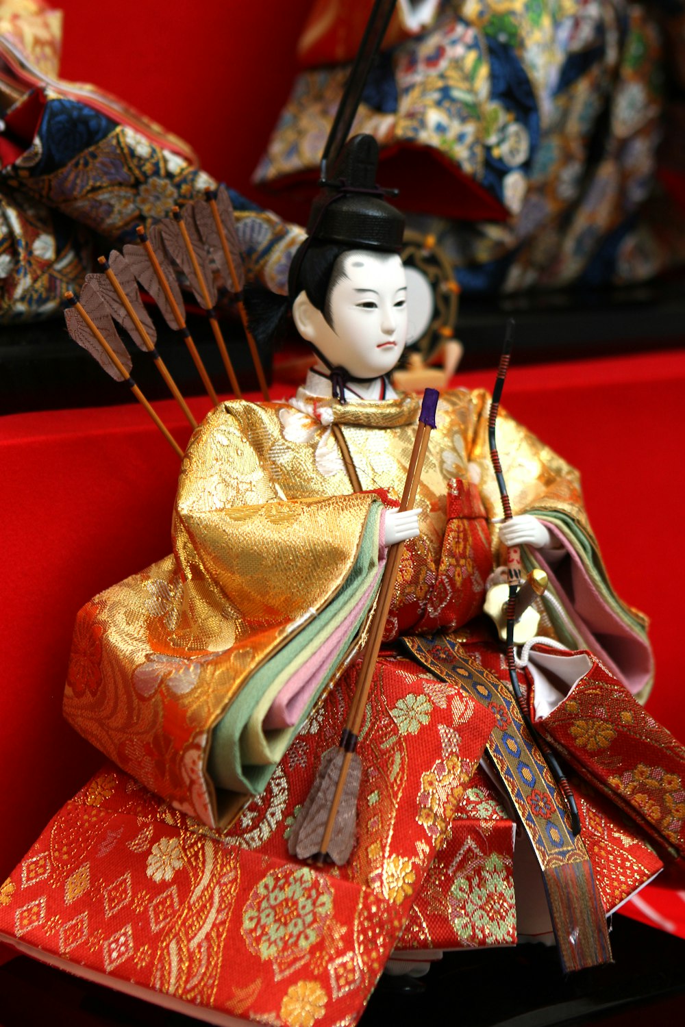 a geisha doll sitting on top of a pile of fabric