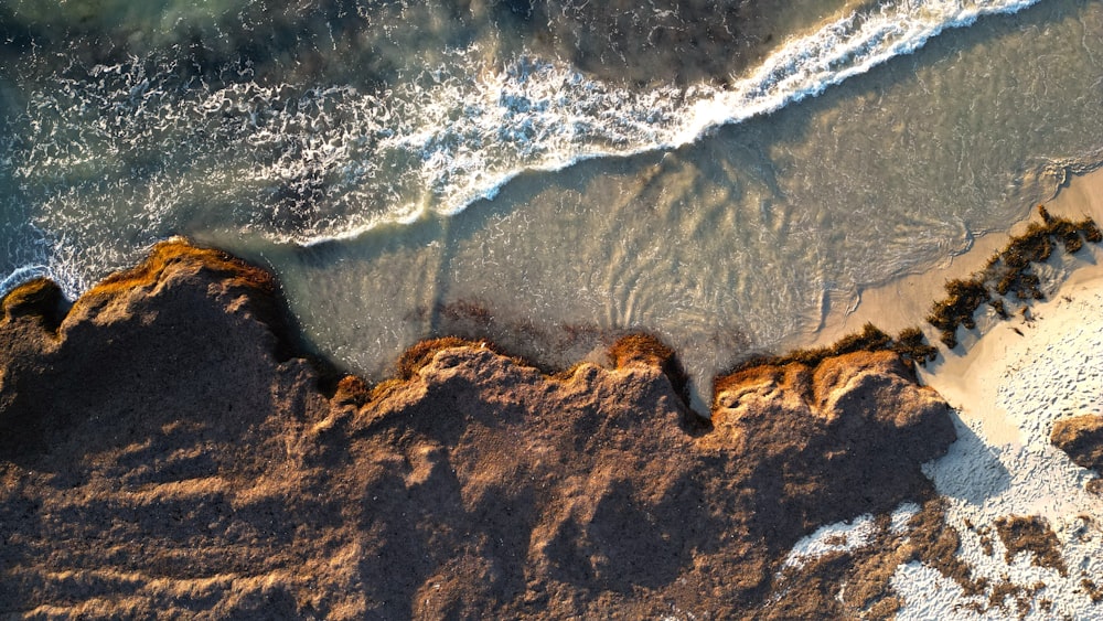 an aerial view of a beach with waves coming in